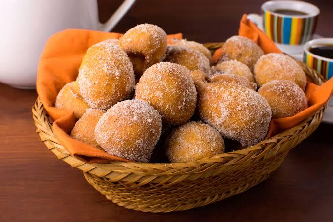 Bolinhos de chuva em uma cestinha com um pano por baixo laranja