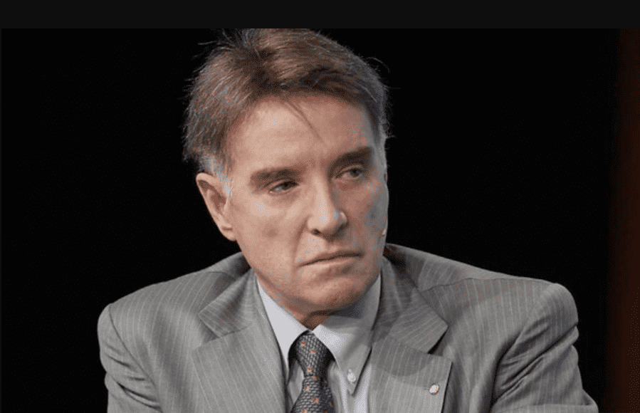 Foto mostra Eike Batista com a expressão séria, homem branco, de cabelos grisalhos, vestindo terno e gravata.