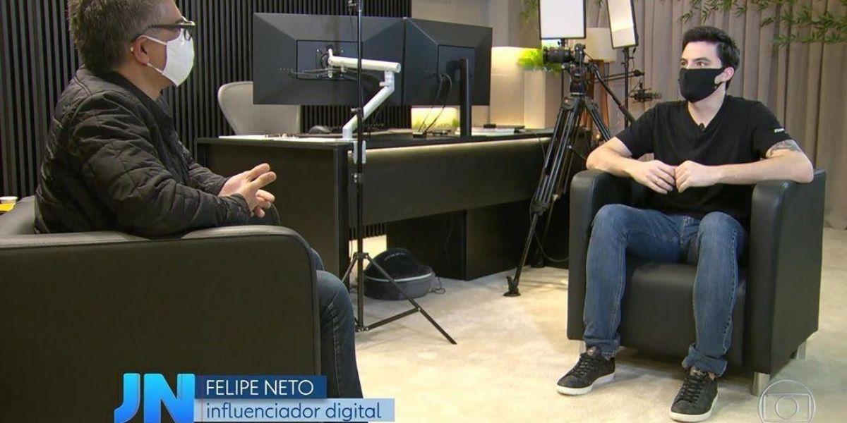 Felipe neto sentado de frente para o repórter em entrevista ao jornal nacional