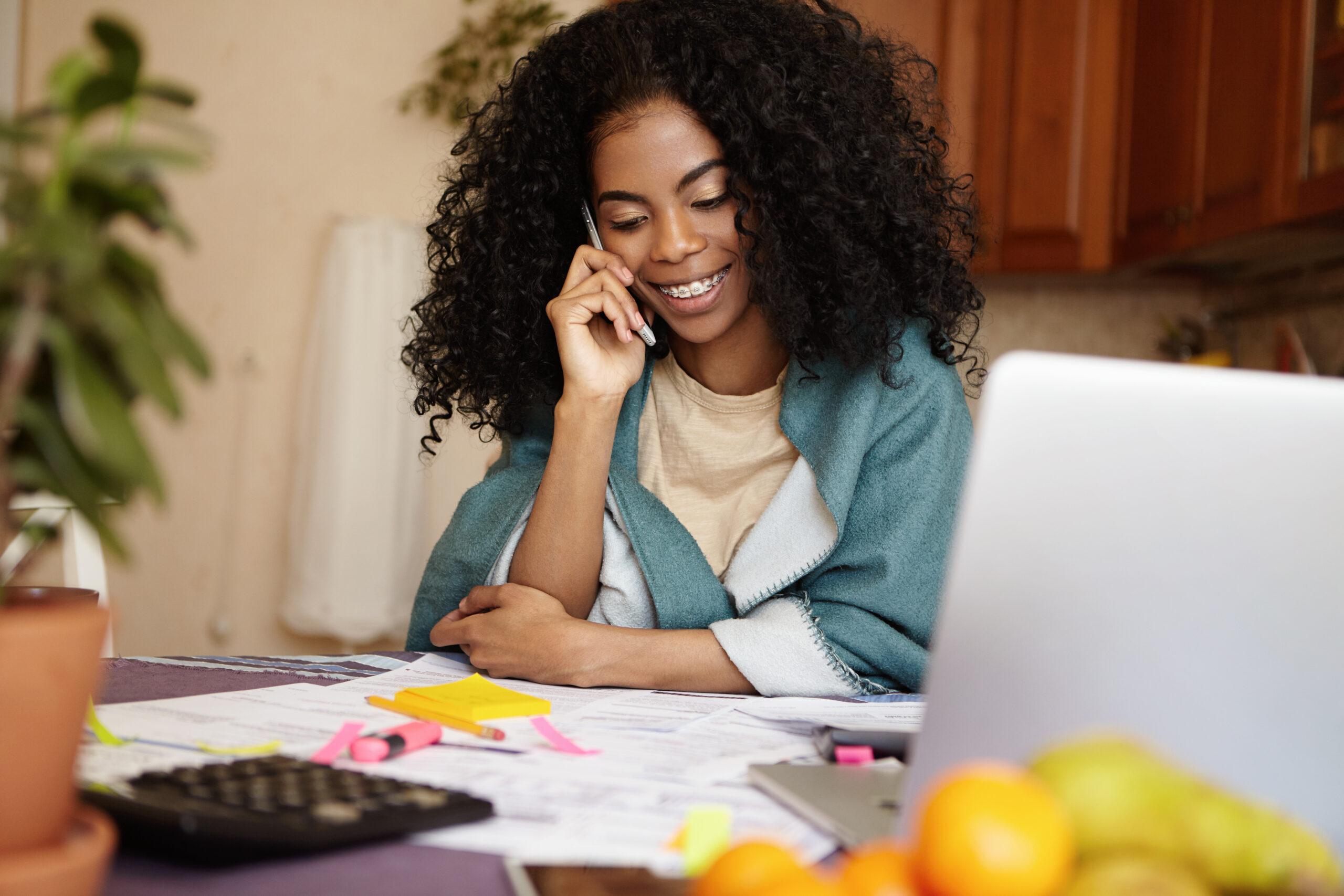 Freelancer trabalhando em casa, conversando ao telefone