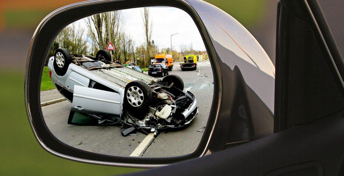 imagem refletida no retrovisor carro capotado em rodovia