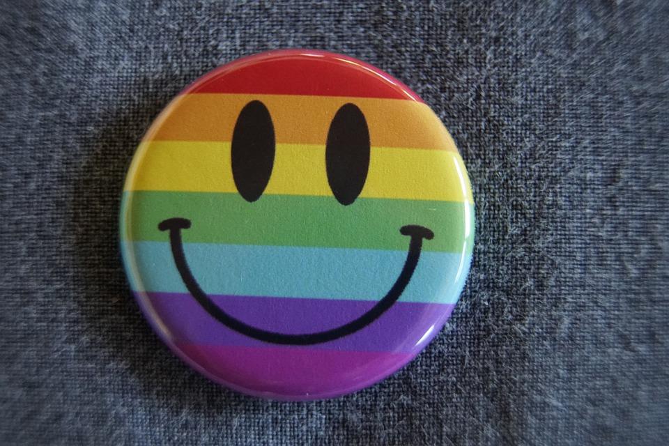 Botão com emoji de sorriso com as cores da bandeira lgbtqi+