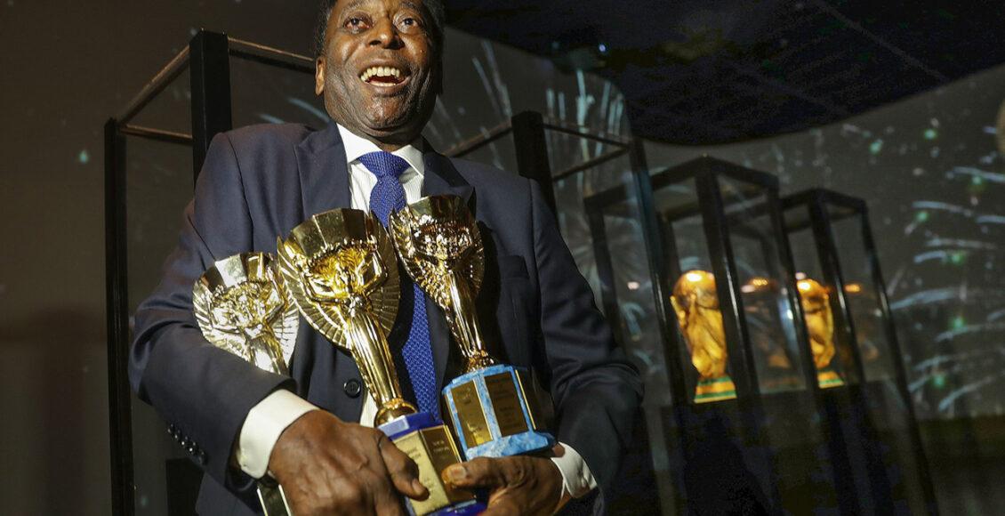 Pelé segura três Copas do Mundo, um de seus recordes