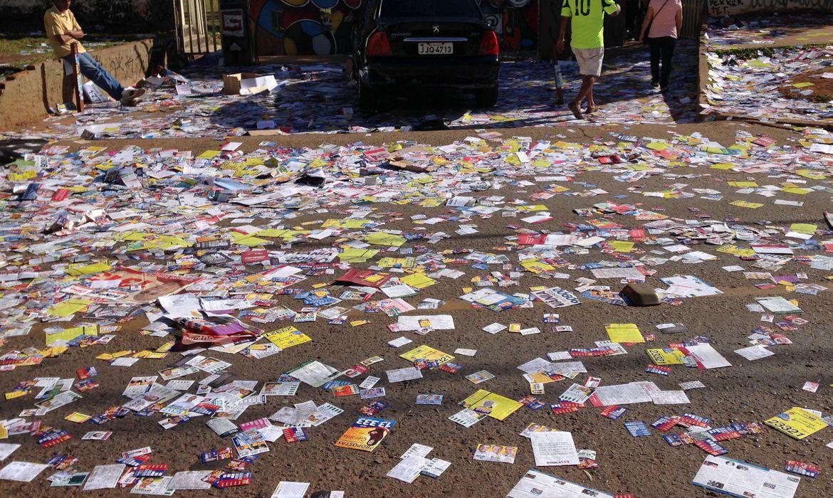 Foto mostra rua cheia de santinhos eleitorais