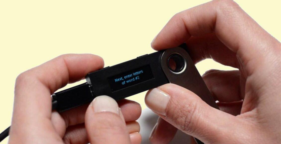 segurando hardware wallet Ledger Nano