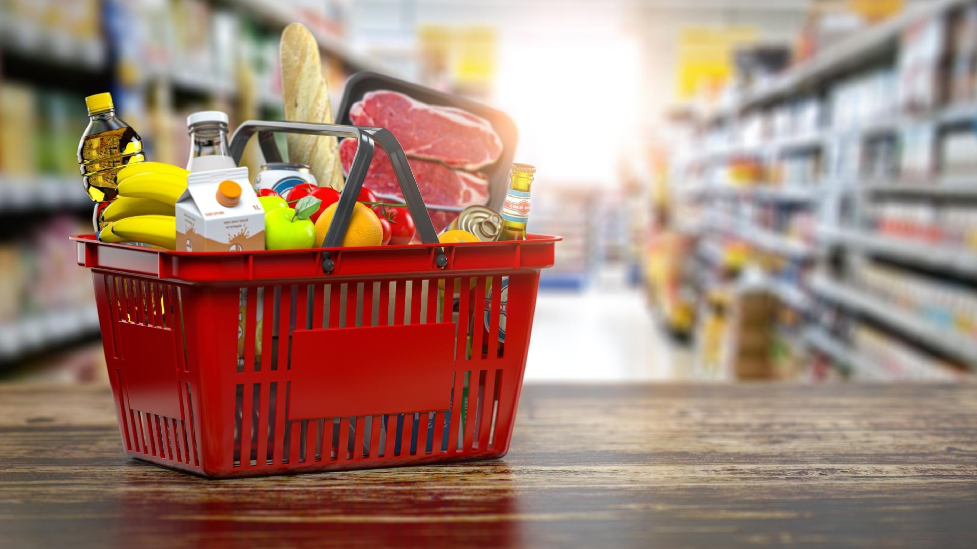 A imagem mostra uma cesta de supermercado com diversos produtos