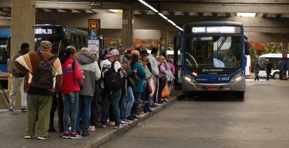 Fila de passageiros a espera de ônibus.