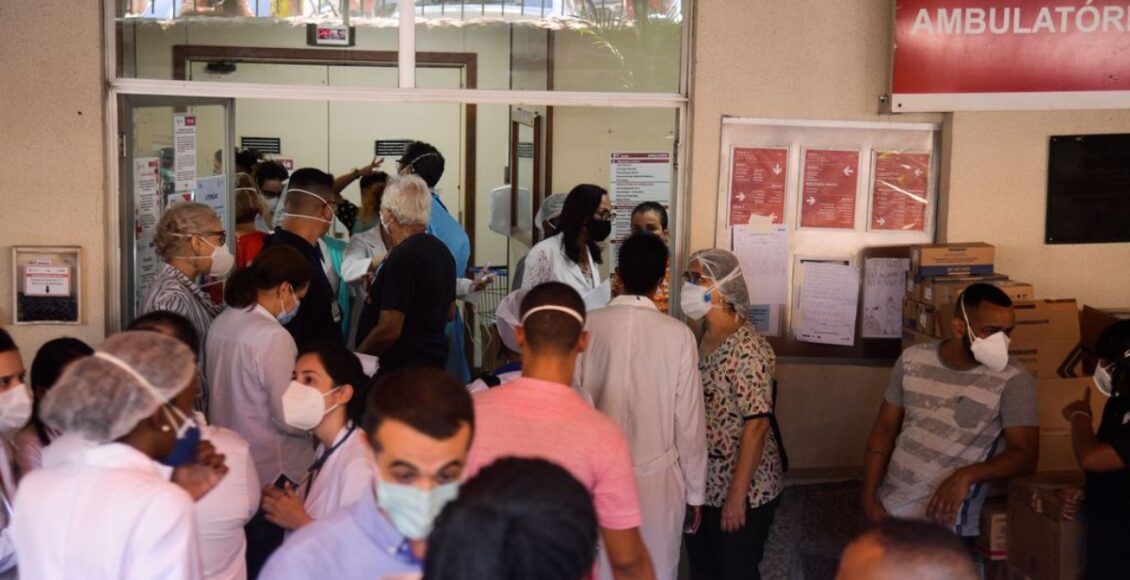 Imagem mostra pessoas na porta de um hospital. Pandemia afetou diretamente o PIB do país em 2020